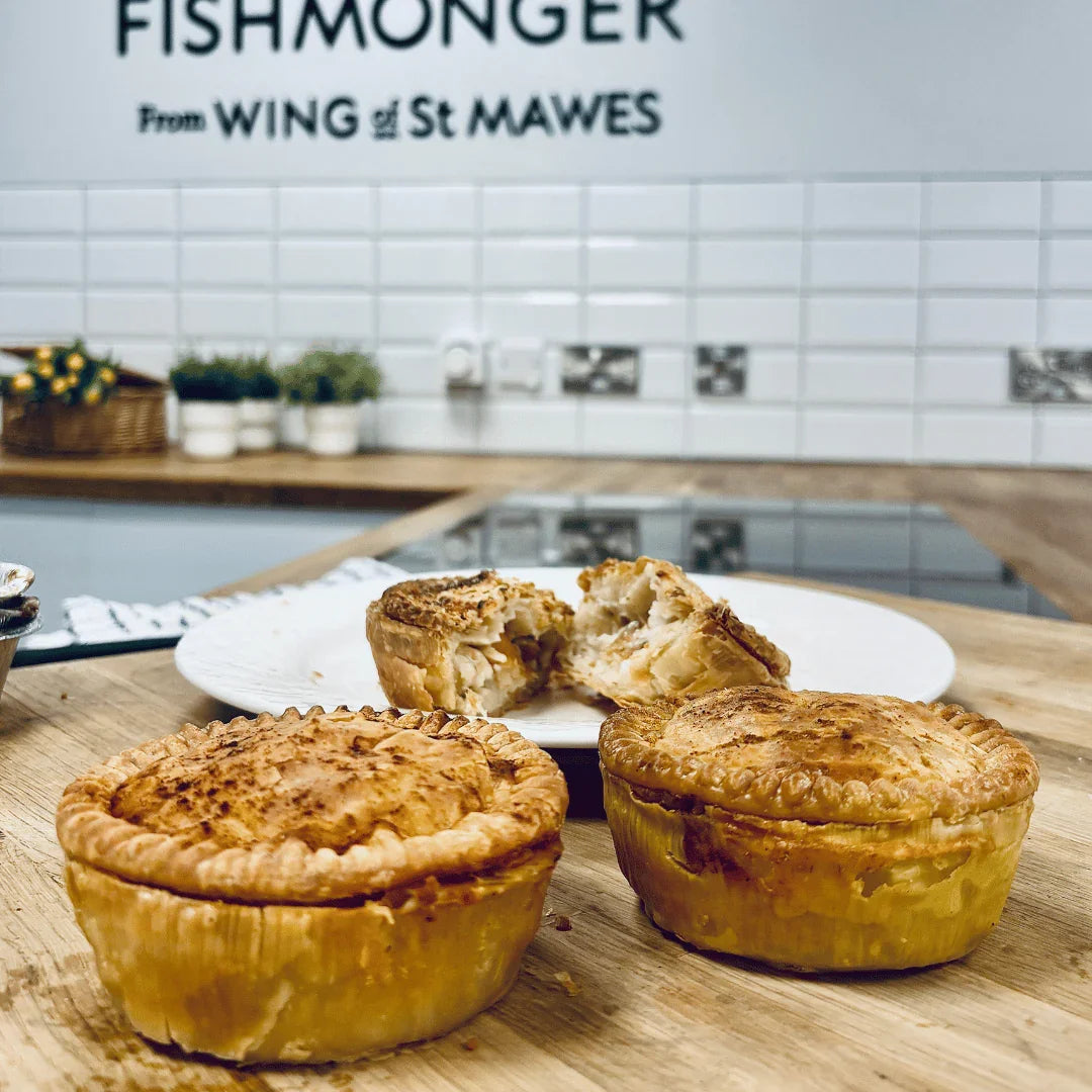 Freshly baked fish pies with golden crust on wooden counter in modern kitchen setting