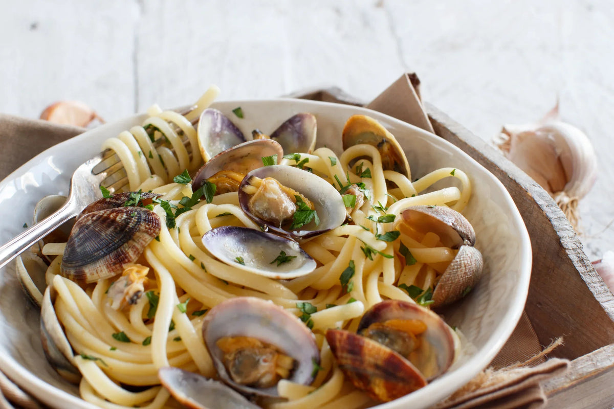Spaghetti alle vongole with fresh clams and parsley in a ceramic bowl
