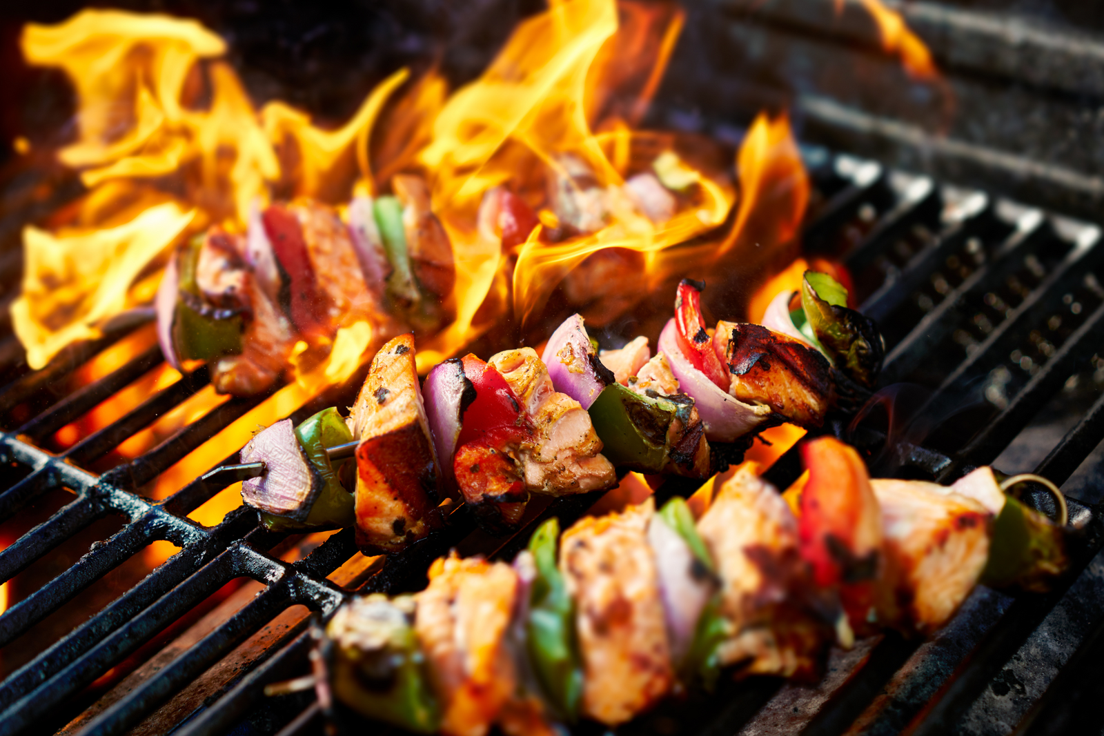 Seafood skewers with vegetables grilling over open flame barbecue