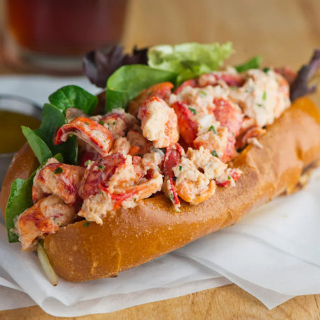 Fresh lobster roll with chunks of lobster meat and salad in a toasted brioche bun