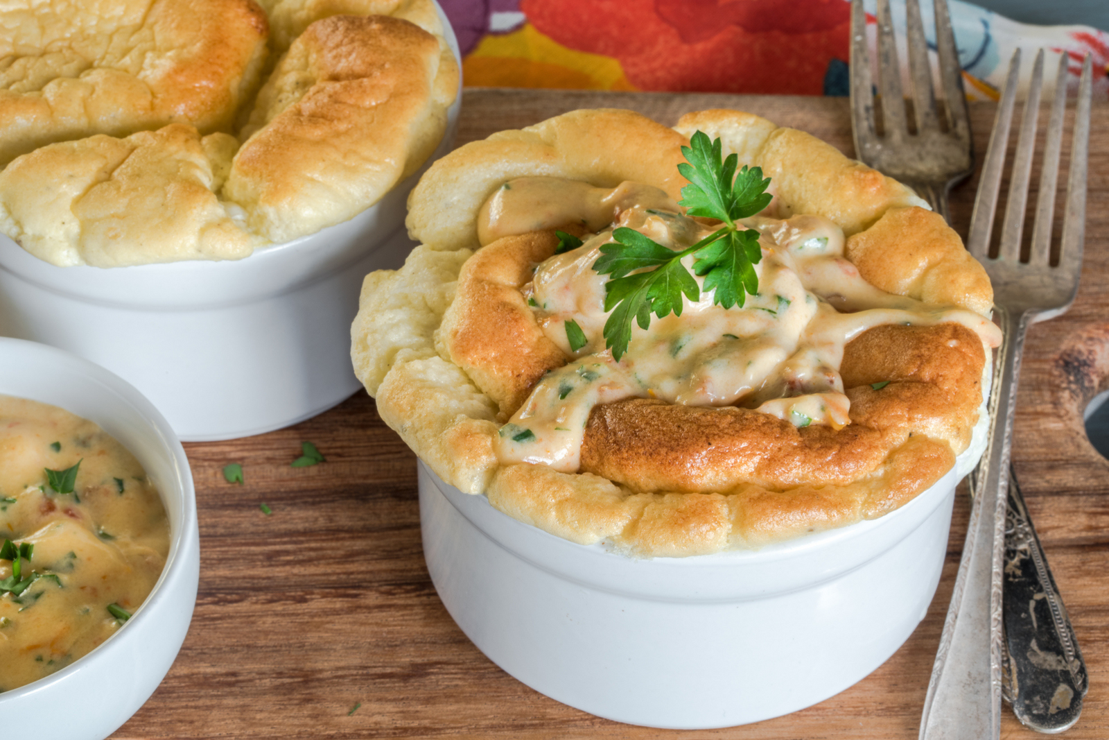 Golden smoked salmon soufflé in a ramekin, topped with creamy herb sauce and parsley