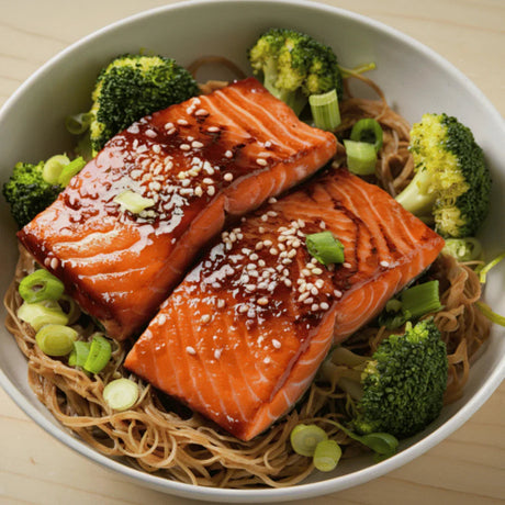 Spicy teriyaki glazed salmon fillets on noodles with broccoli and sliced green onions