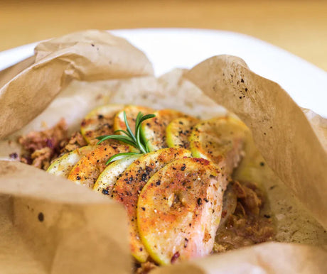 Trout en papillote with lemon slices, herbs, and spices baked in parchment paper