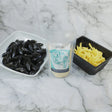 Fresh mussels in a bowl, fries, and marinière sauce kit on marble background